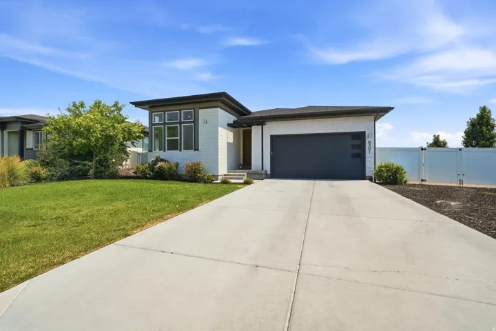 Modern exterior with multi-pane windows, a dark garage door, and a concrete driveway
