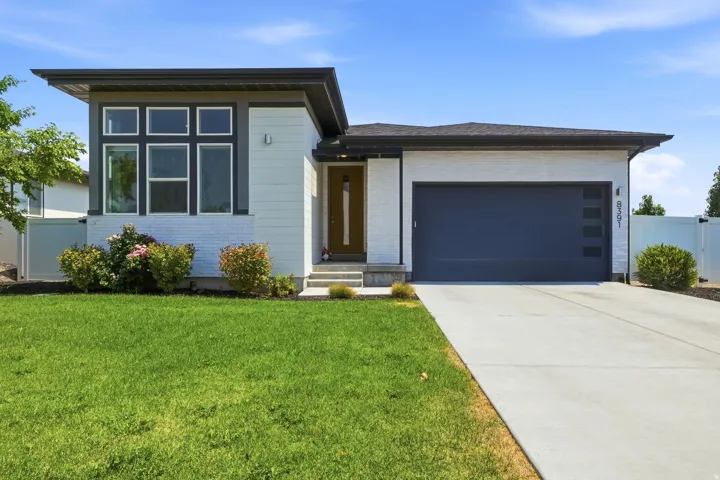 Modern home featuring a clean-lined architectural design with a white exterior and dark roof accents