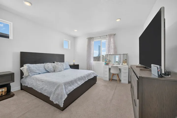 Recessed lighting, large window with natural light, two high windows, and light-colored carpeting