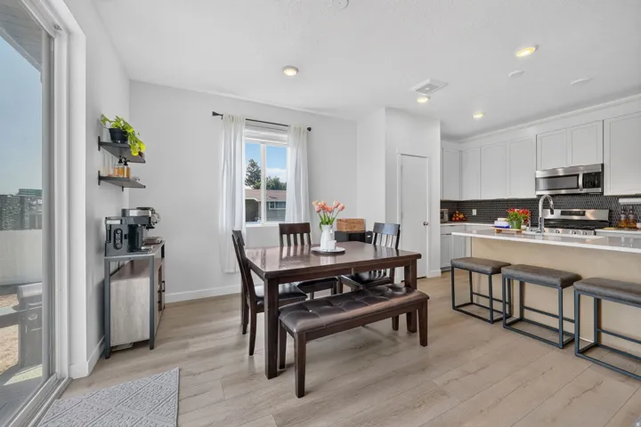 Open-concept living space with wood-finish flooring, recessed lighting, and a sliding glass door