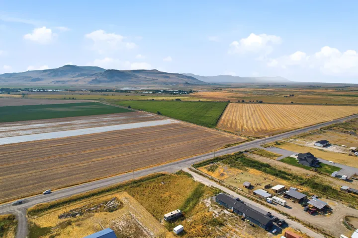 Expansive agricultural fields with distant mountainous terrain under a clear sky