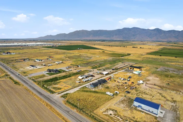 Expansive property with a paved road frontage, surrounded by agricultural fields and distant mountains