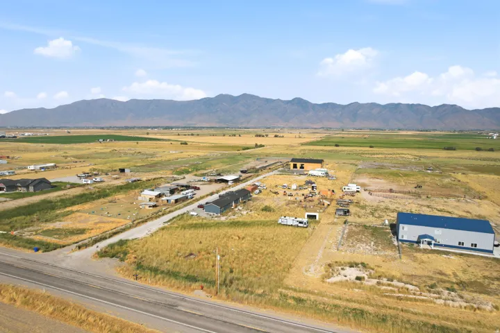 Expansive rural landscape featuring distant mountains and a clear sky