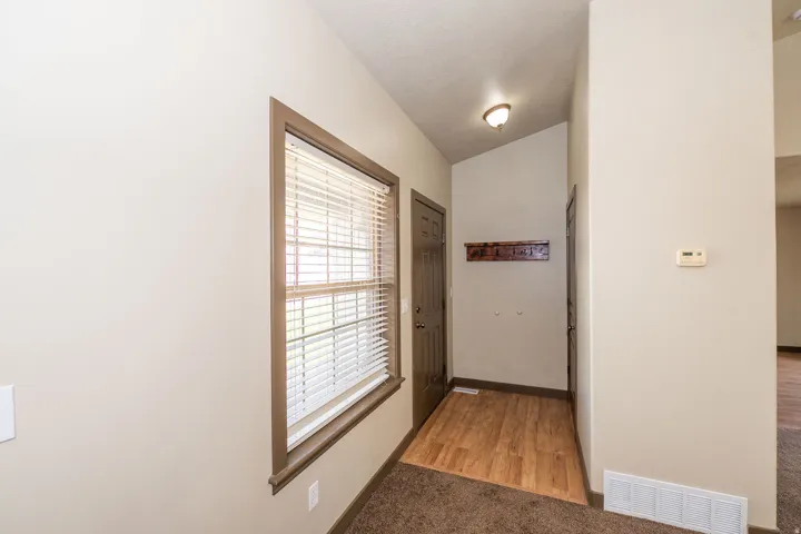 Entryway featuring wood-finish flooring, a window with blinds, and a built-in coat rack