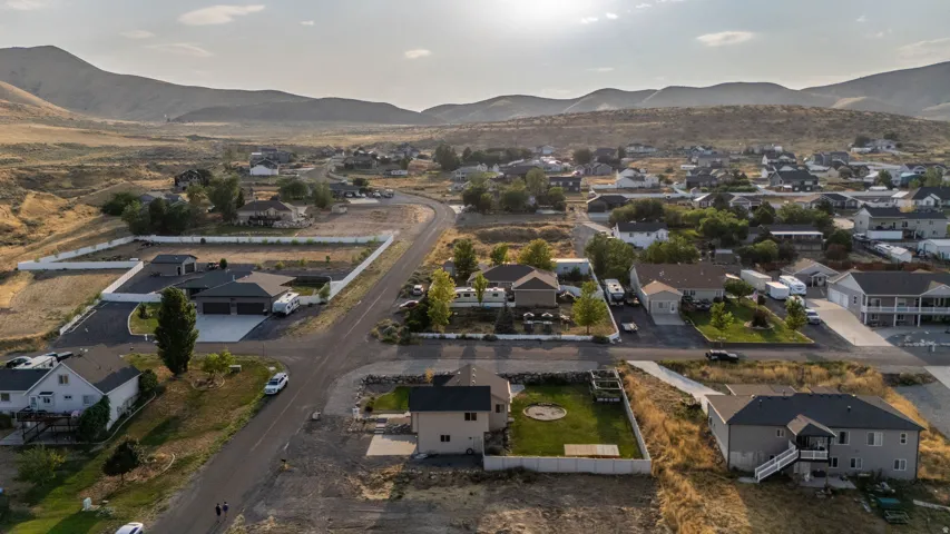 Residential development with paved roads and established homes, surrounded by natural mountainous terrain