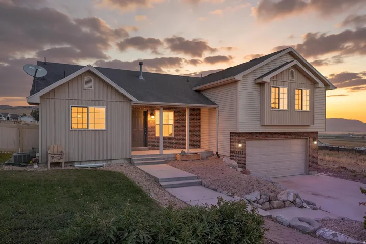 Two-story residence featuring a combination of brick and siding, a covered front entry, a two-car garage, and a concrete driveway