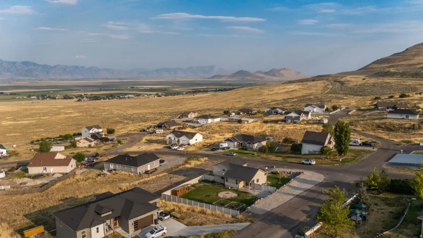 Expansive rural setting featuring a residential community, paved roadways, and distant mountain ranges