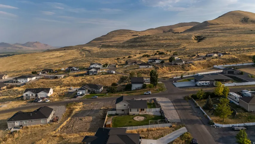 Residential properties situated on a sloping landscape with visible mountainous terrain