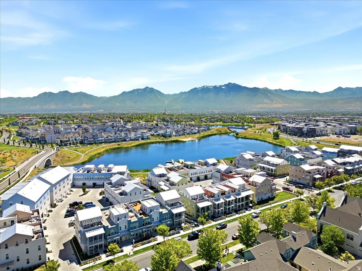 Community featuring a prominent lake, lush green spaces, and mountain backdrop