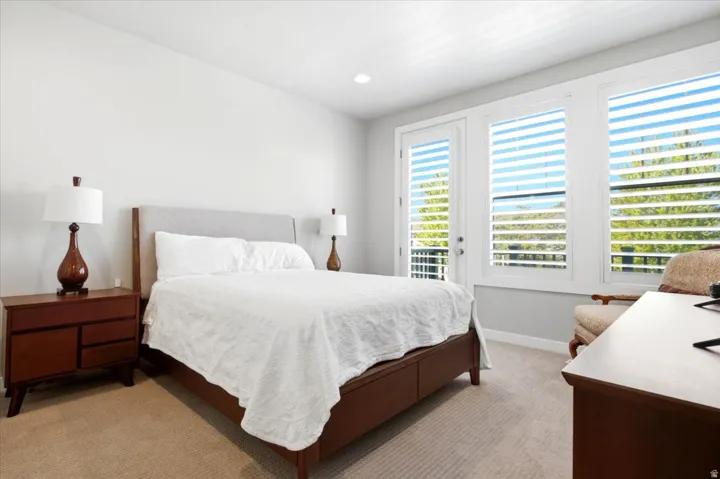 Recessed lighting, light-colored walls, white plantation shutters, glass-paneled door, and carpeted flooring