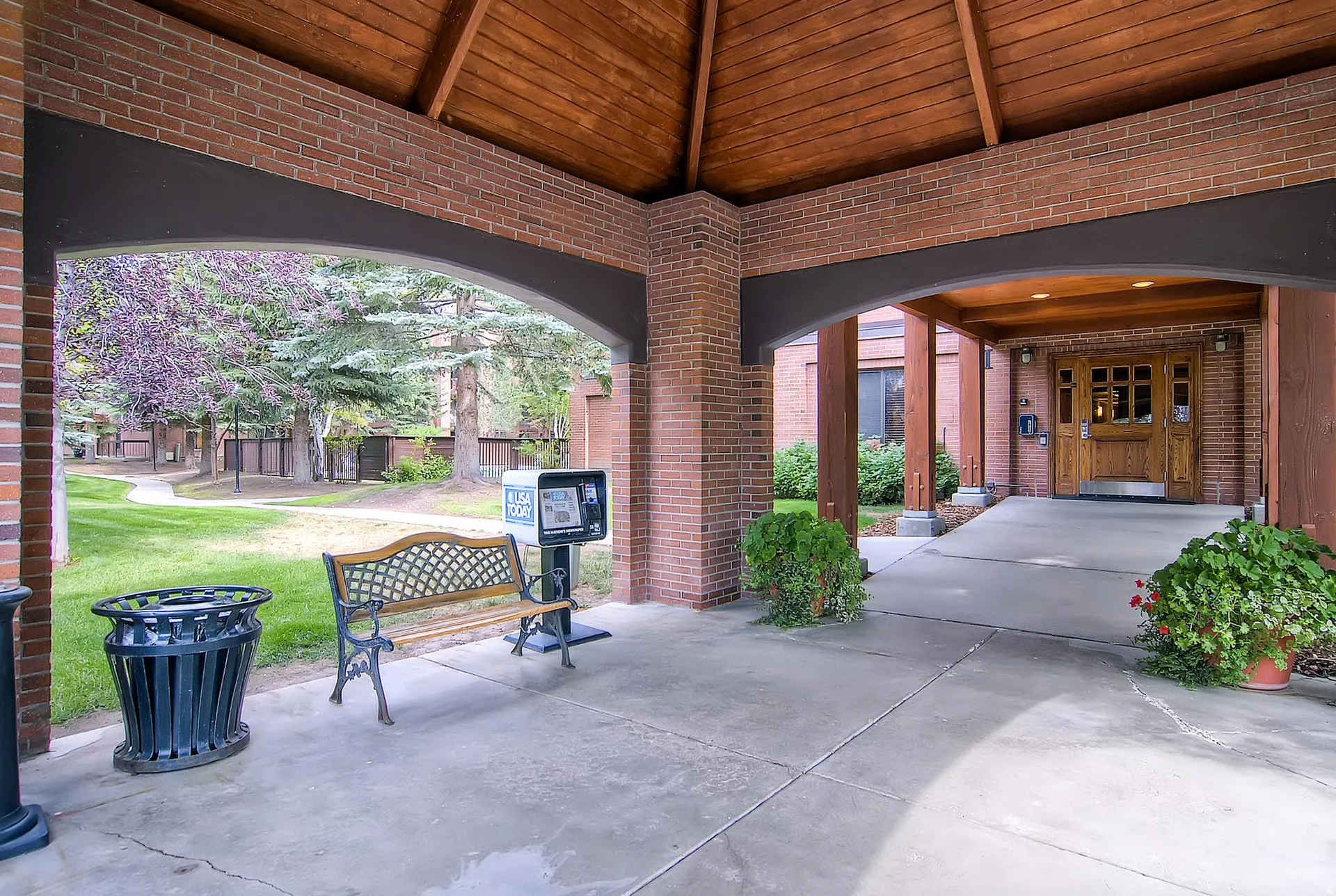 Covered brick entryway featuring a distinctive arched ceiling with exposed wood paneling