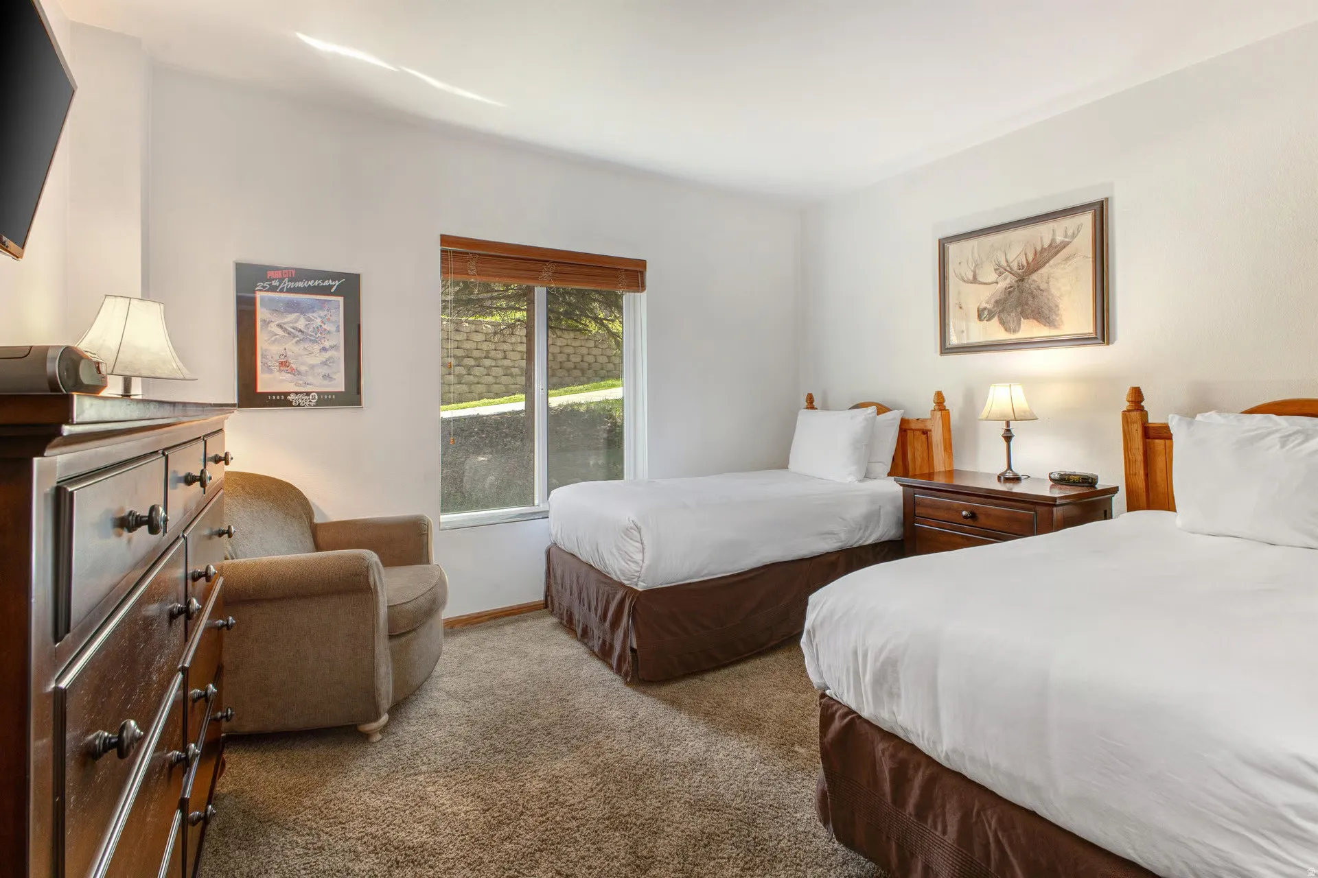 Carpeted room featuring two single beds with coordinating dark wood bed frames and nightstands