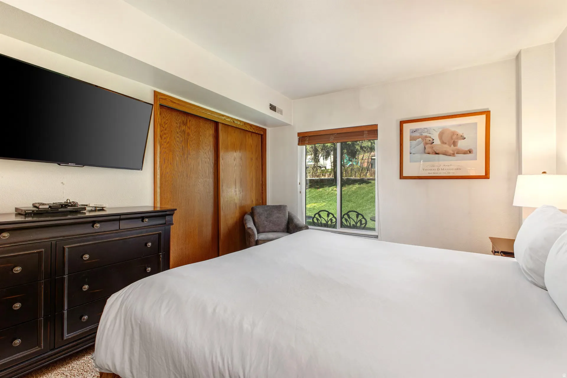 Bright bedroom with a window offering a green outdoor expanse