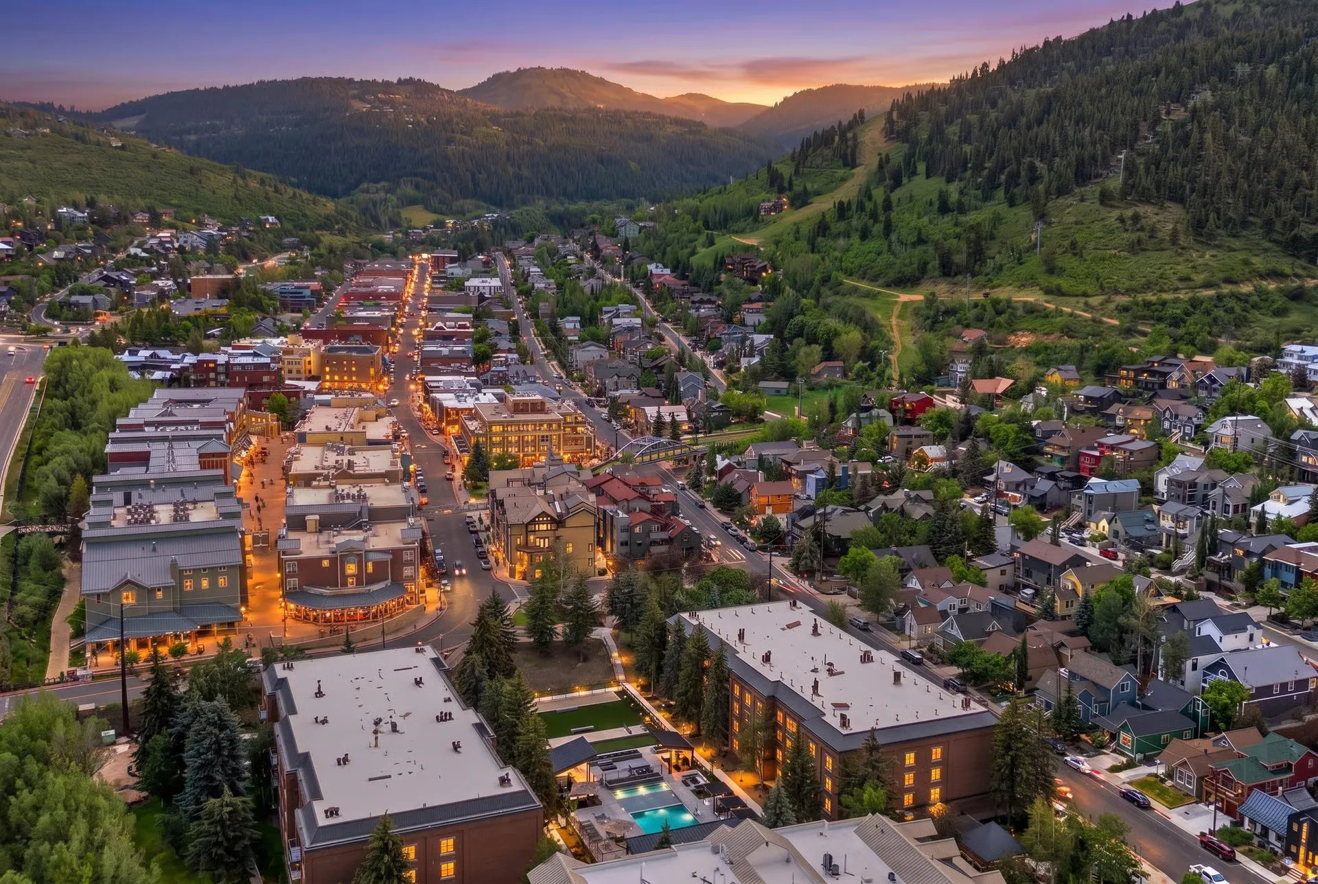 Aerial perspective of a vibrant downtown district with commercial buildings lining a main thoroughfare
