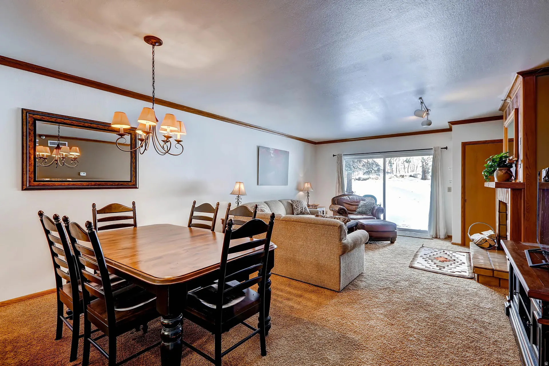 Open-concept living area featuring a dining space with a wrought iron chandelier