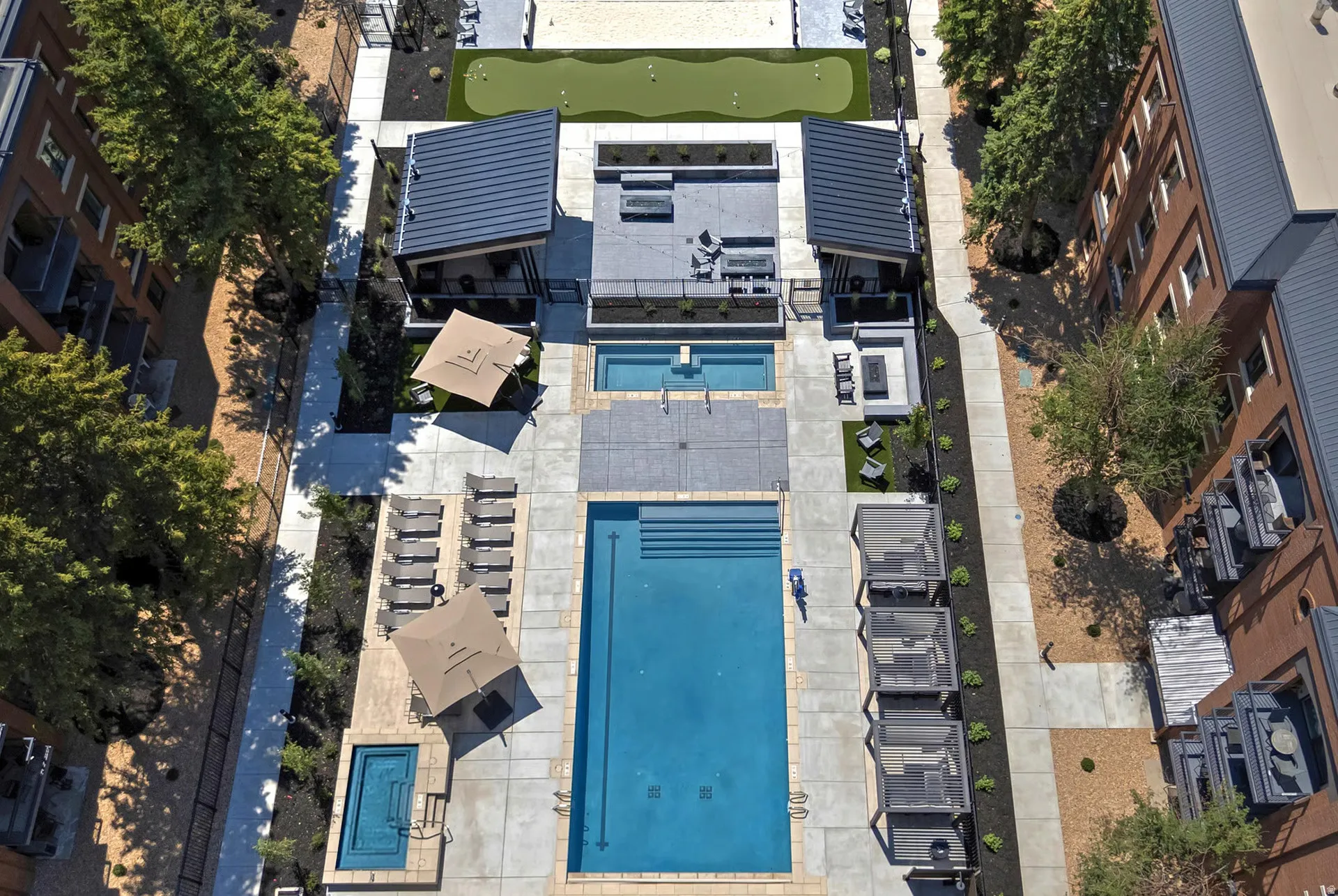 Outdoor amenity courtyard featuring a rectangular swimming pool, an additional smaller pool, and a putting green