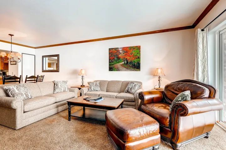 Living area featuring wall-to-wall carpeting and a glass sliding door