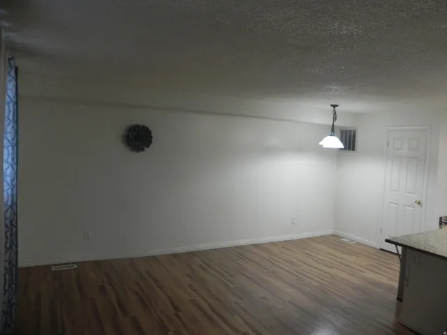 Wood-finish flooring with white baseboards throughout