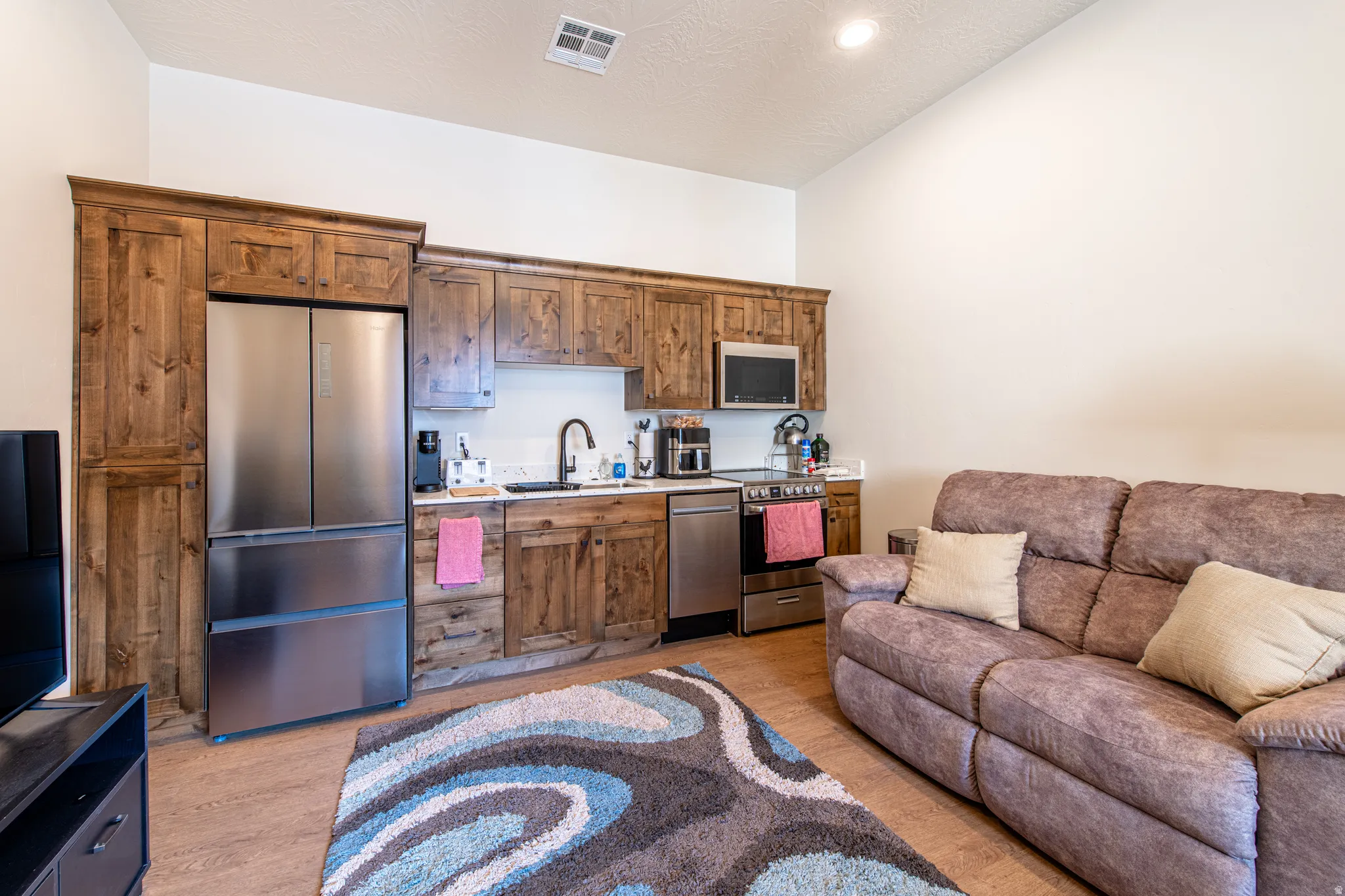 Wood-finish cabinetry, stainless steel appliances, wood-finish flooring, and recessed lighting