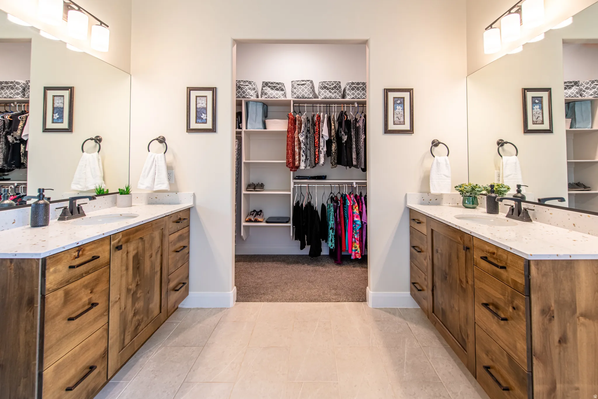 Dual vanities with wood-finish cabinetry, integrated sinks, and individual mirrors