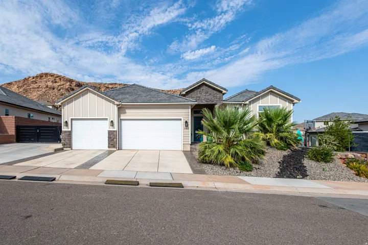 Contemporary exterior with a stone and siding facade, concrete driveway, and two garage doors