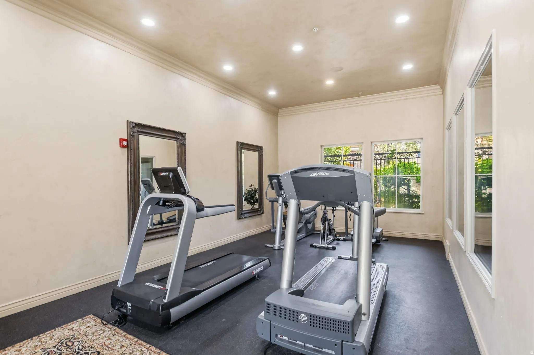 Recessed lighting illuminates the cream-colored walls and dark flooring