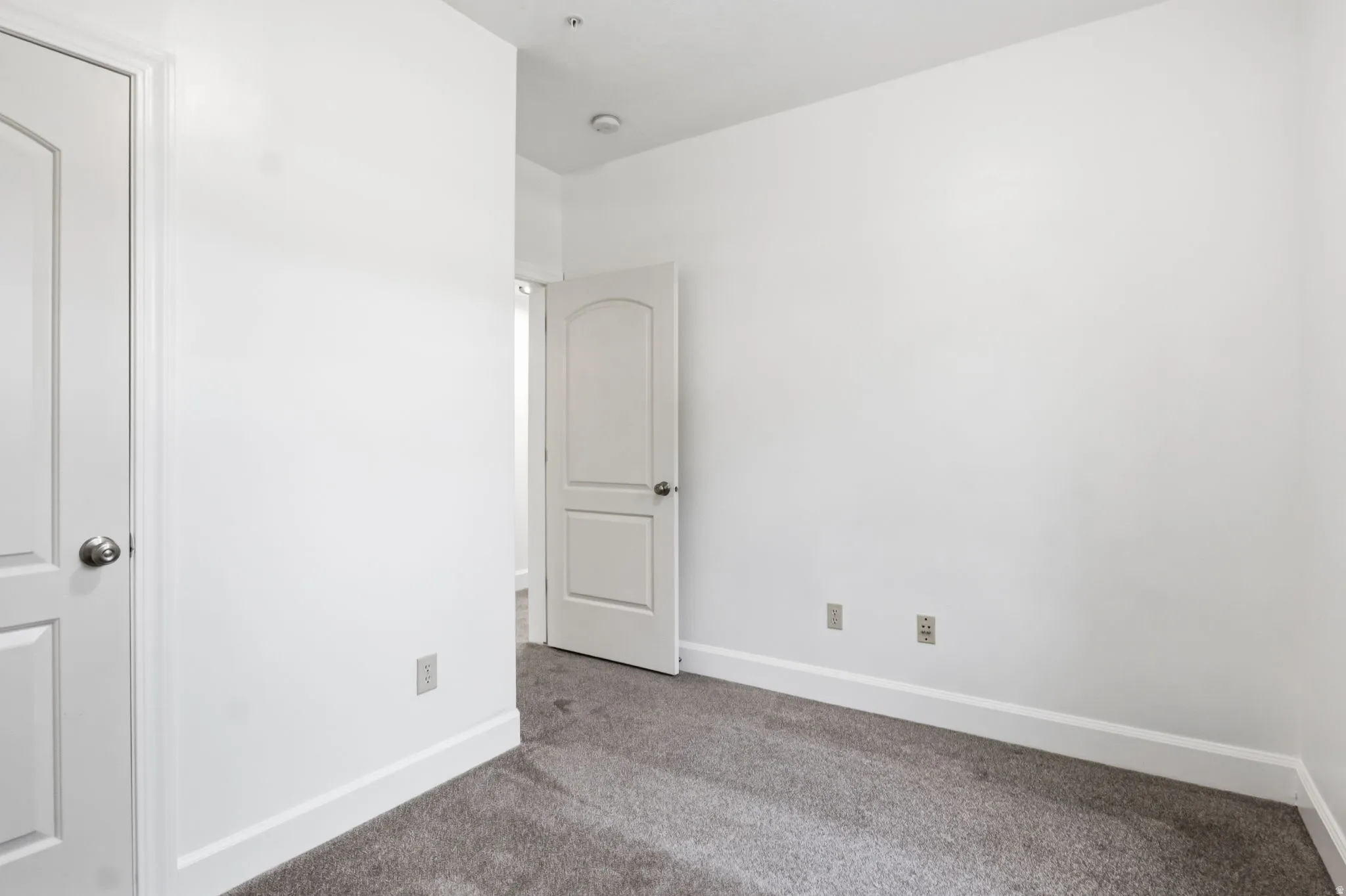 Neutral white walls, white trim, and gray carpet