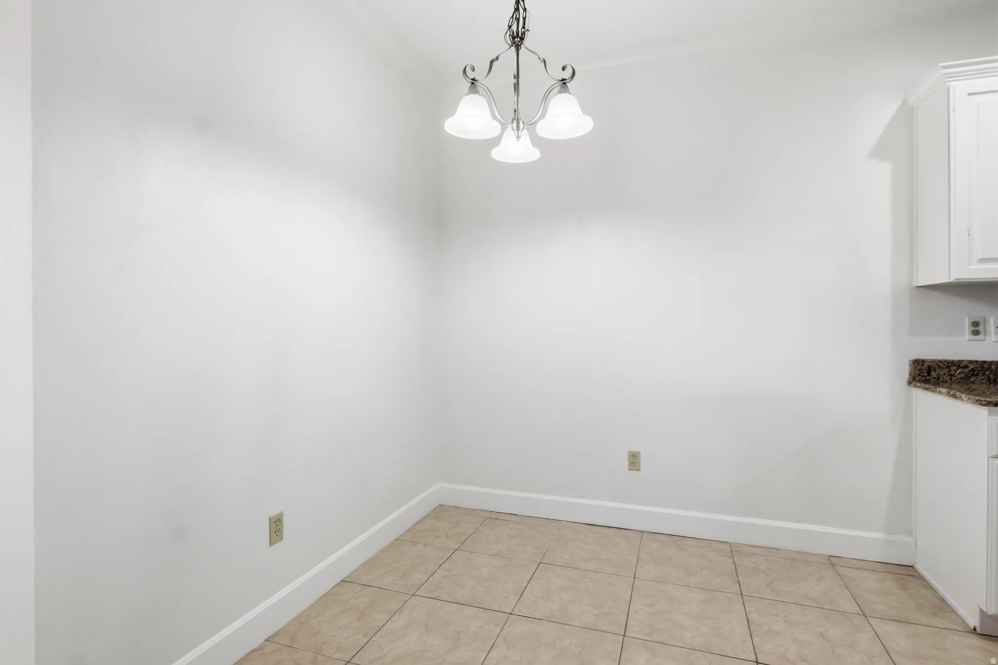 Porcelain tile flooring, crown molding, built-in cabinetry, and a granite-finish countertop