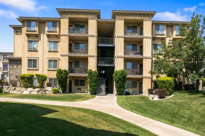 Four-story building with stucco exterior, multiple balconies, and exterior stair access