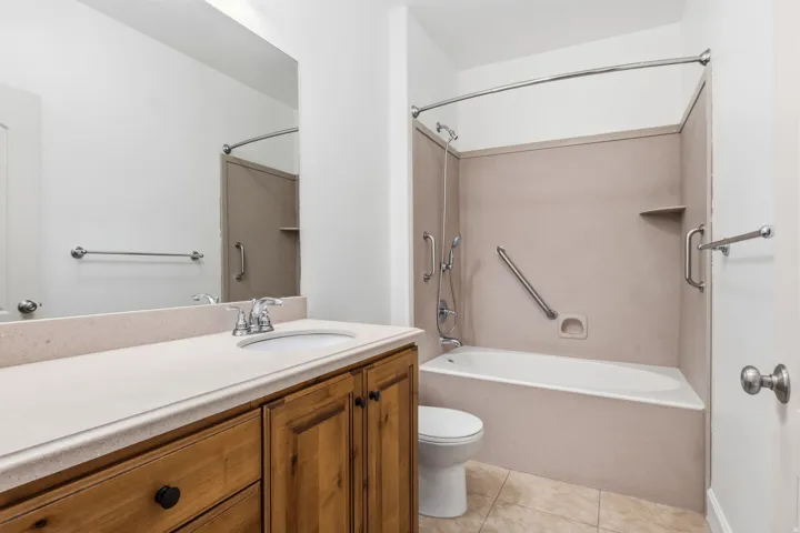 Vanity with integrated sink, chrome faucet, and wood-finish cabinetry