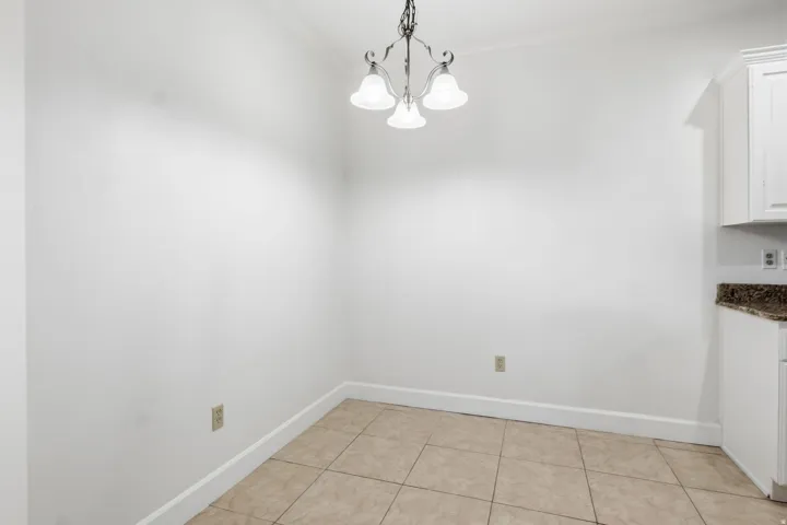 Porcelain tile flooring, crown molding, built-in cabinetry, and a granite-finish countertop