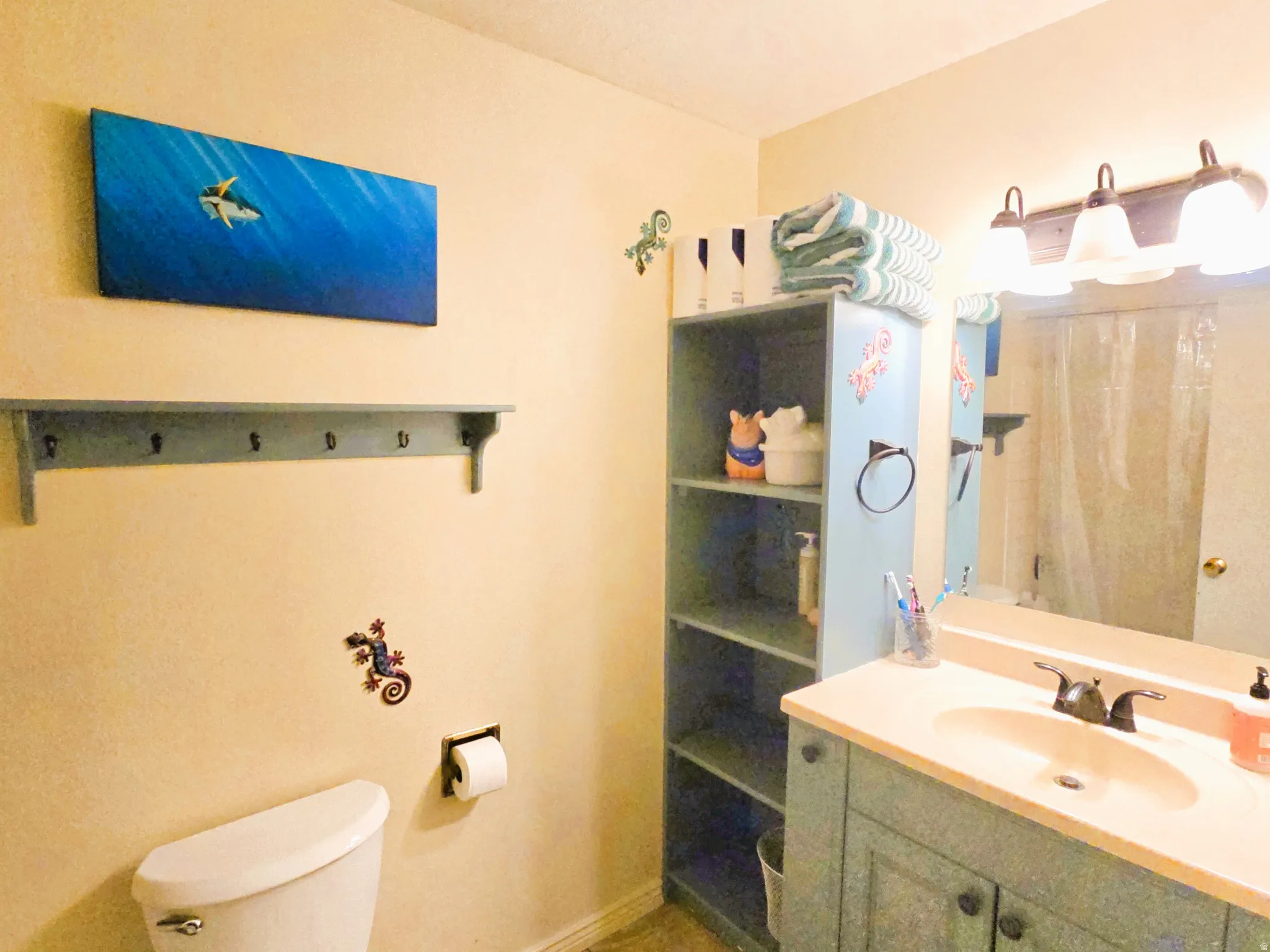 Vanity with integrated sink, wall-mounted mirror, and a three-light fixture