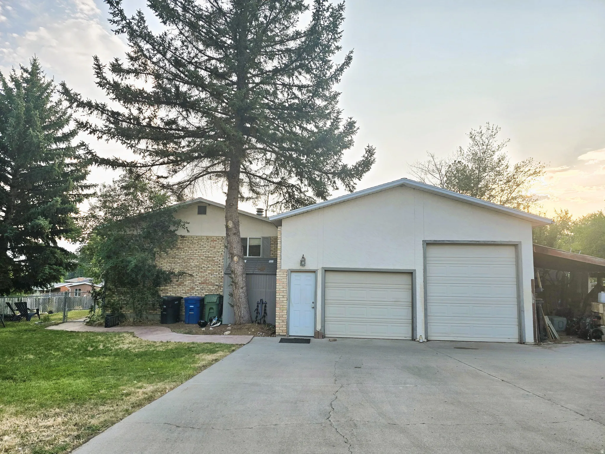 Two-bay garage with overhead doors, an additional side entry door, and a concrete driveway