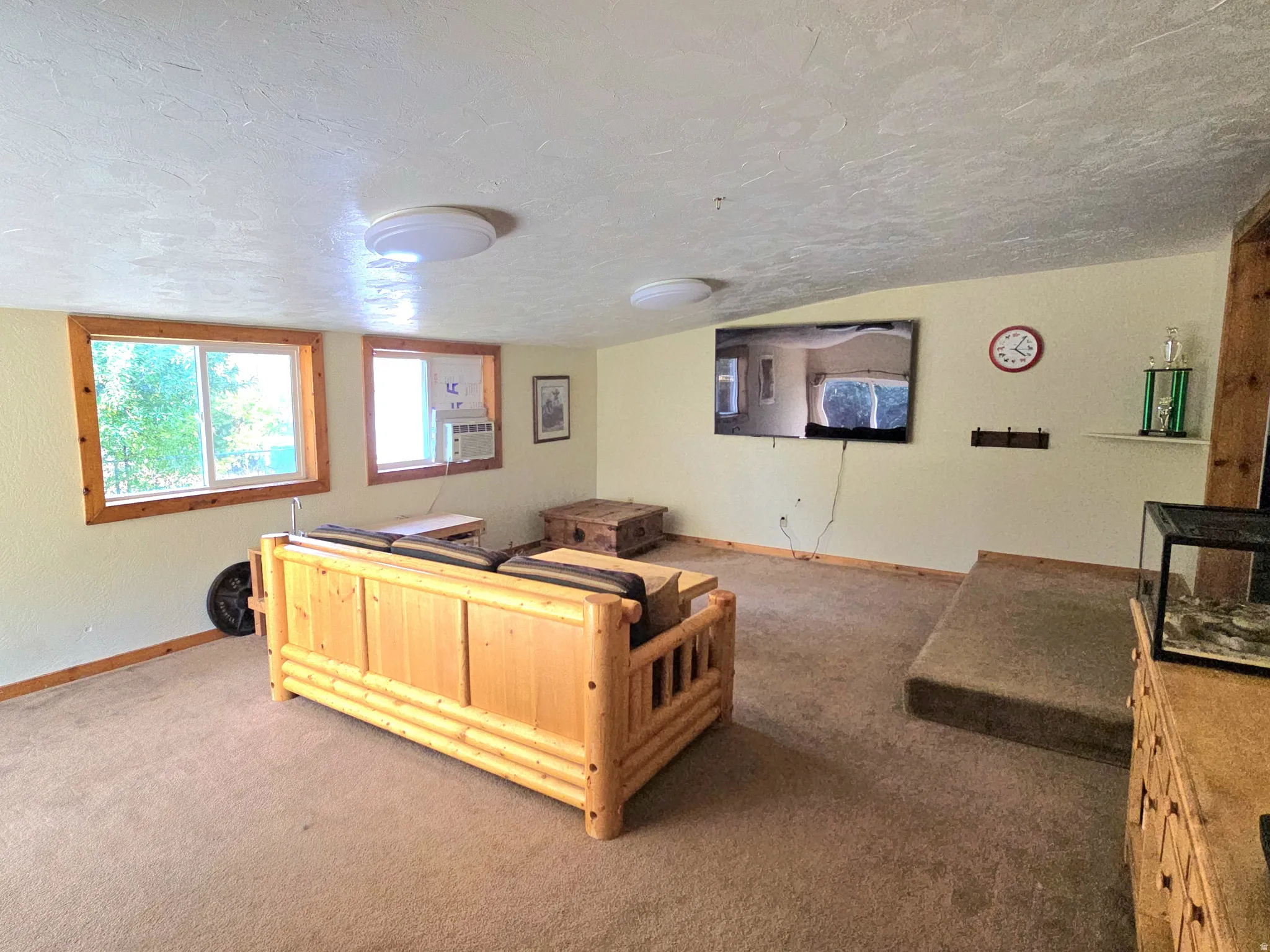 Carpeted flooring, recessed window, wood-trimmed windows, wall-mounted light fixtures, built-in shelving