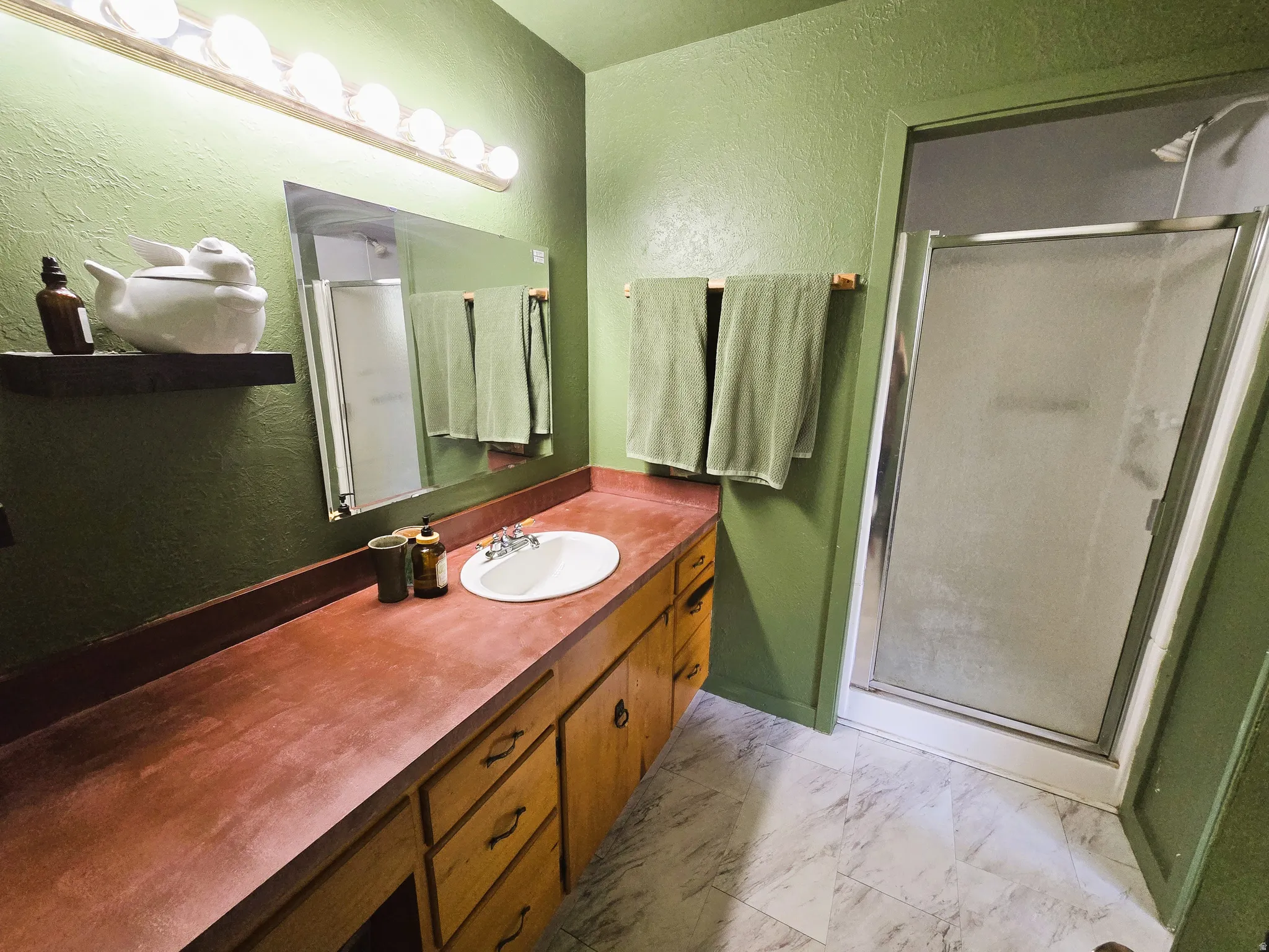 Integrated vanity with a single basin sink, extensive countertop space, and wood-finish cabinetry