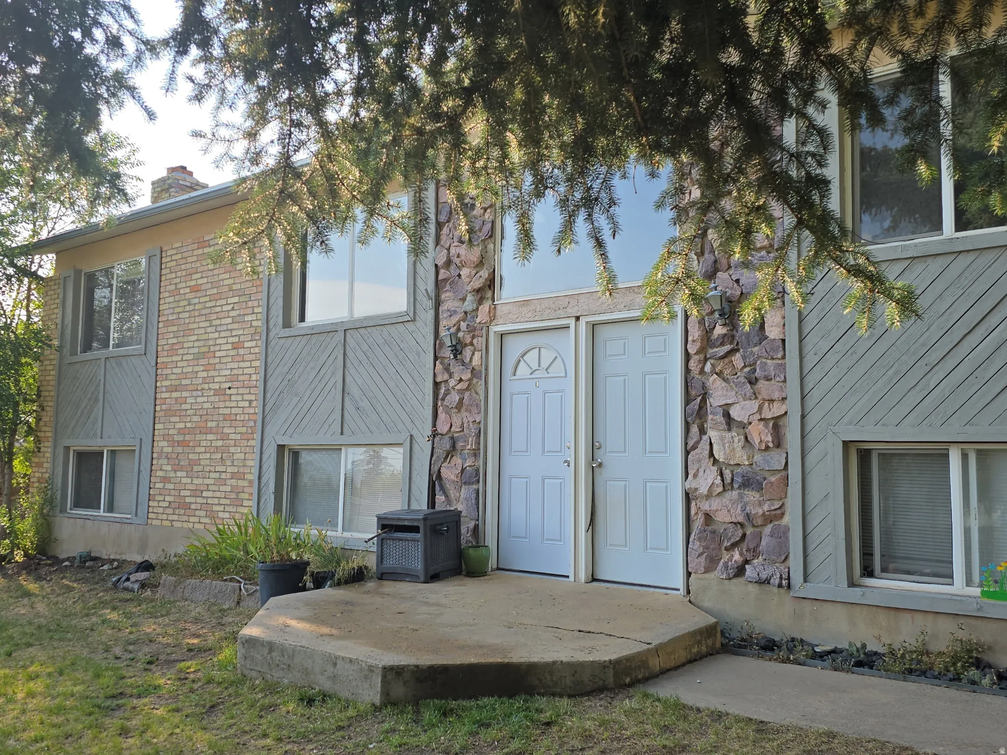 Brick and stone veneer exterior with a concrete entry pad