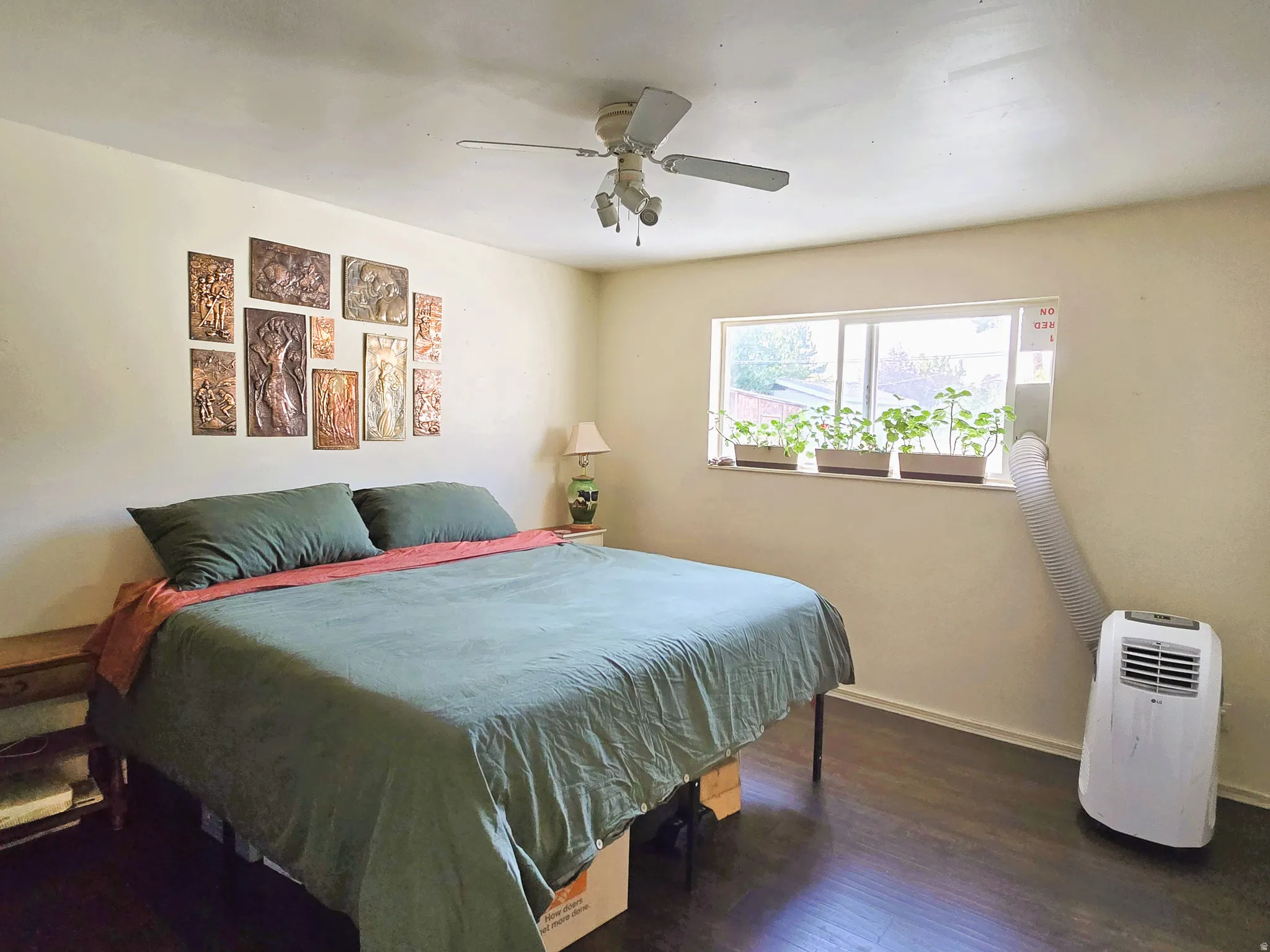 Recessed window, ceiling fan with light fixture, and dark wood-finish flooring