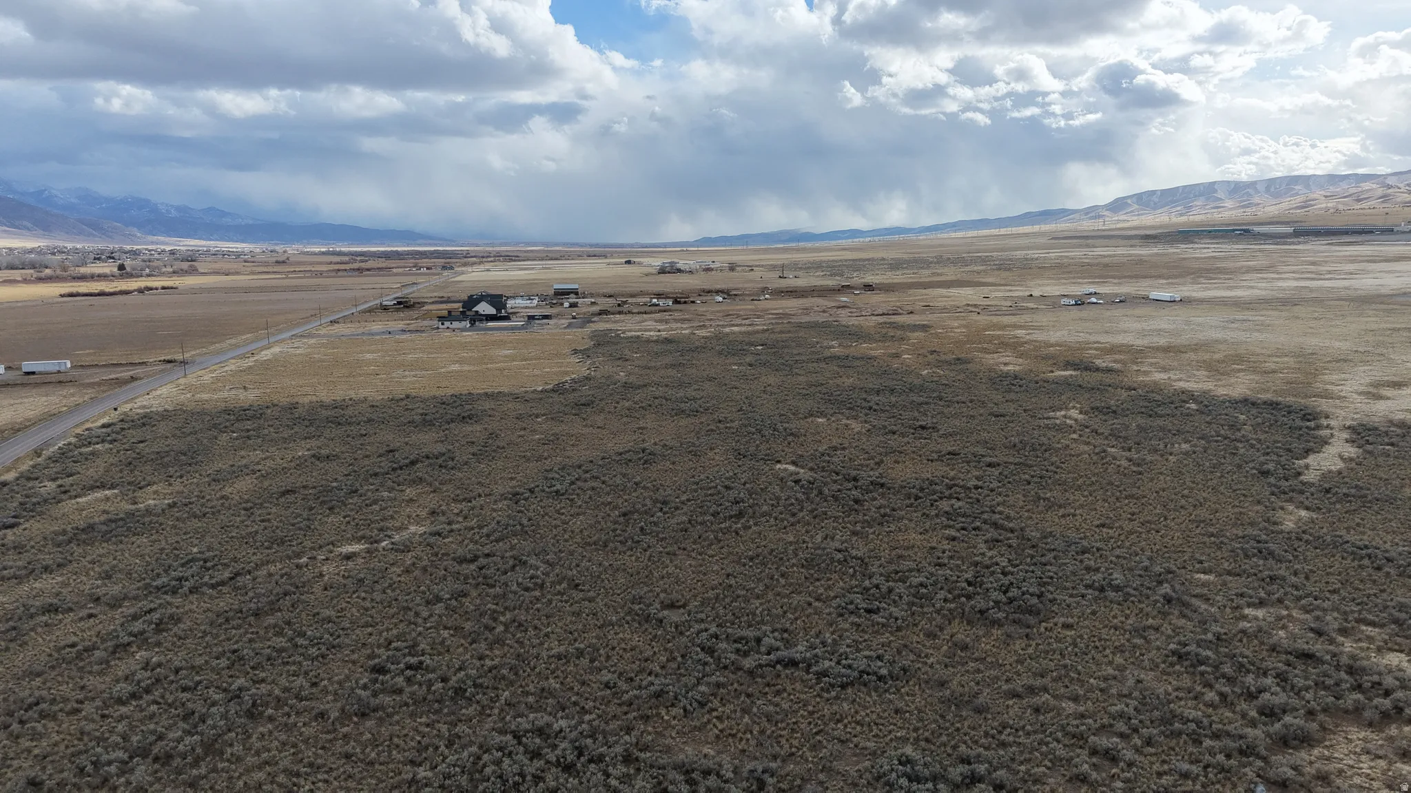 Expansive land parcel featuring natural shrubbery and distant mountain formations