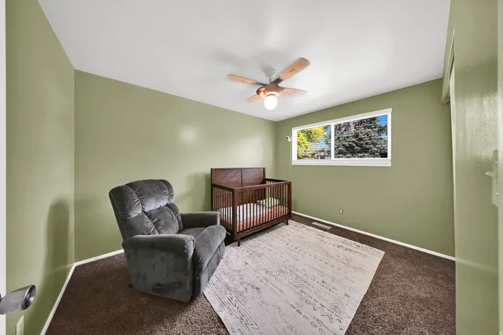 Room featuring a ceiling fan with integrated lighting, a window, and wall-to-wall carpeting