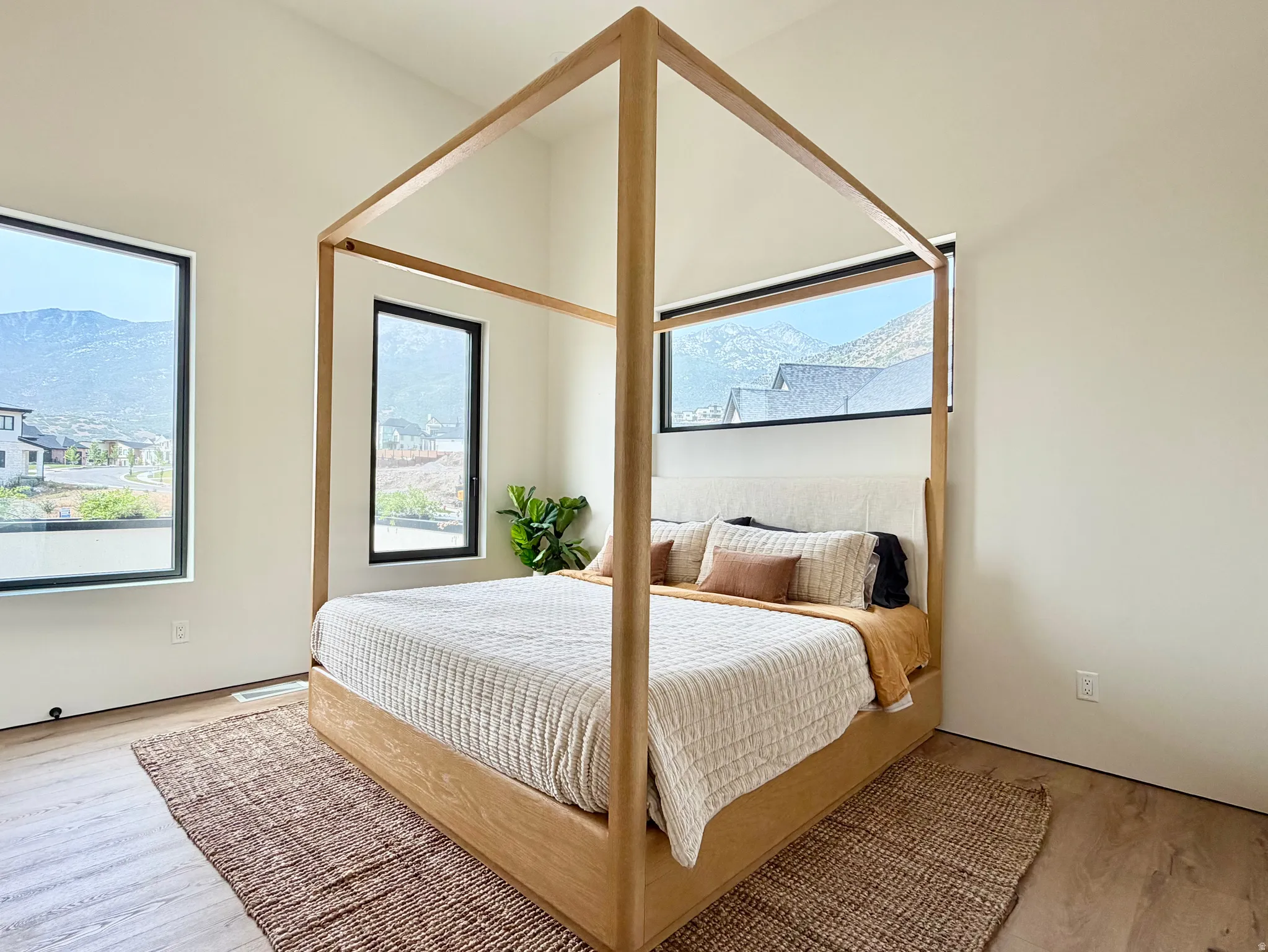 Vaulted ceilings, large black-framed windows, and light wood-finish flooring