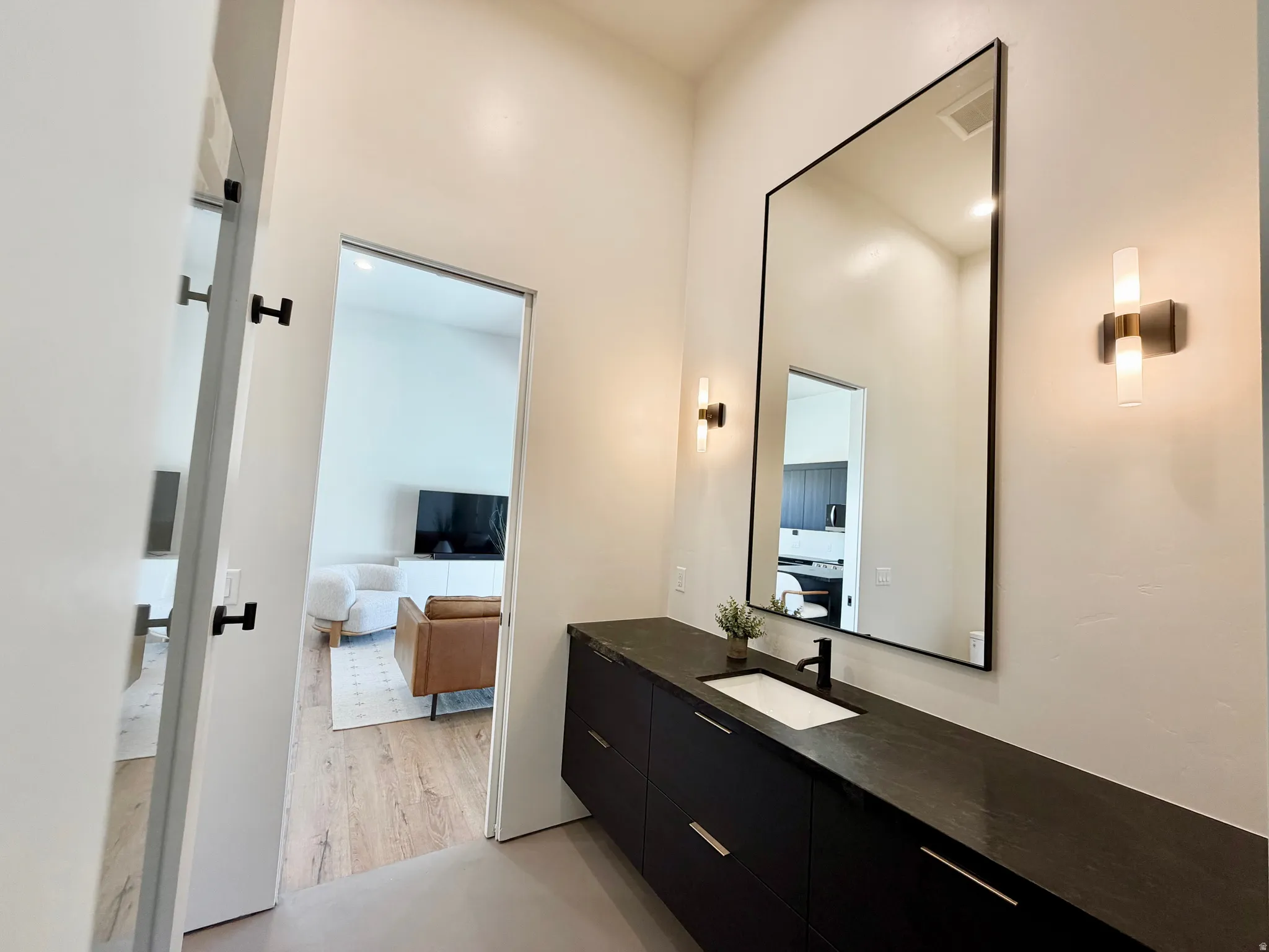 Floating vanity with a built-in rectangular sink, matte black faucet, and dark countertop