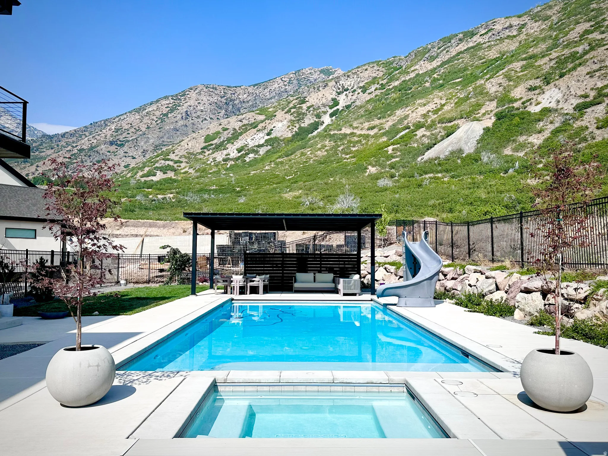 Outdoor swimming pool with integrated spa and adjacent covered patio