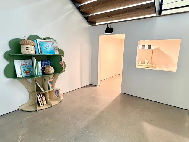 Concrete flooring, integrated wall niche, and modern ceiling beams with integrated lighting