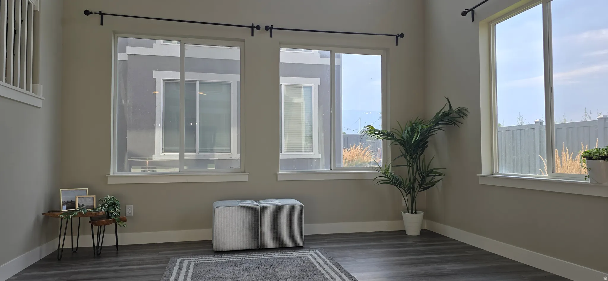 Wood-finish flooring, multiple large windows, and neutral wall tones
