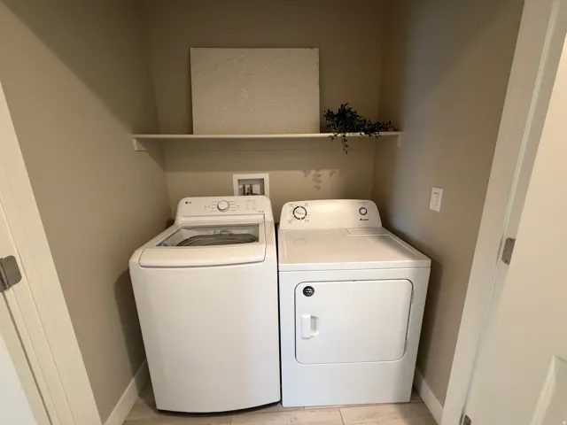 Built-in laundry area featuring a white shelf and light-toned wall paint