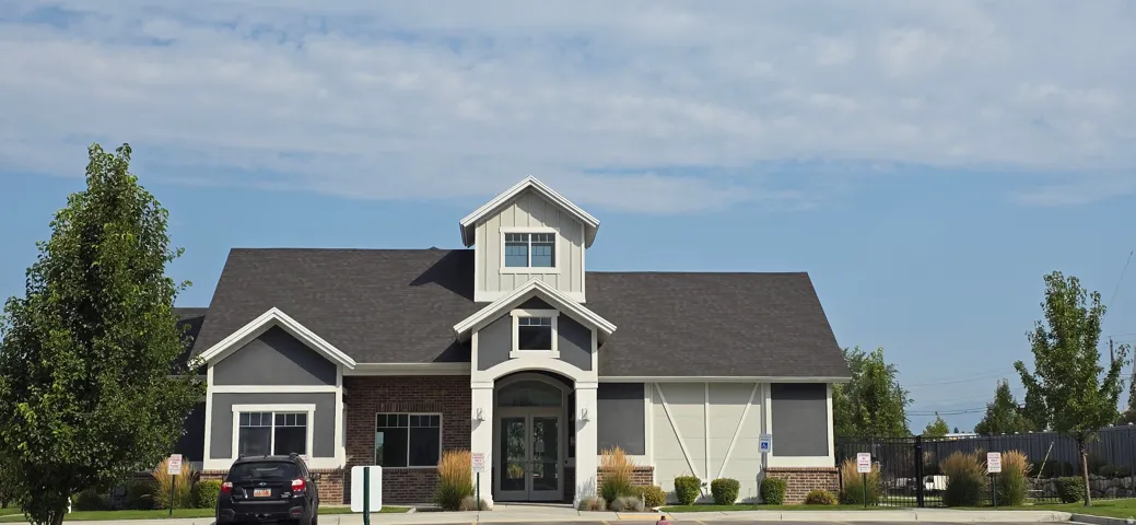 Exterior featuring a gable roof, mixed siding, brick detailing, dormer windows, and a covered entry