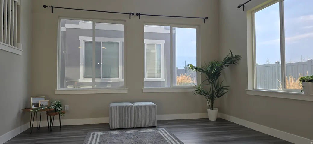 Wood-finish flooring, multiple large windows, and neutral wall tones