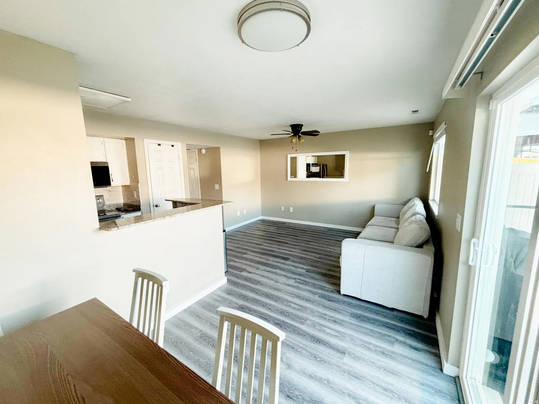 Contemporary interior with wood-finish flooring, a ceiling fan, and a neutral color palette