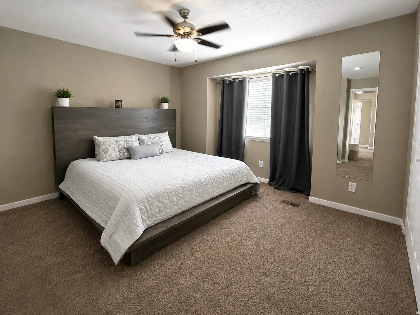 Neutral wall paint, carpeted flooring, window with blinds, and a ceiling fan with integrated lighting