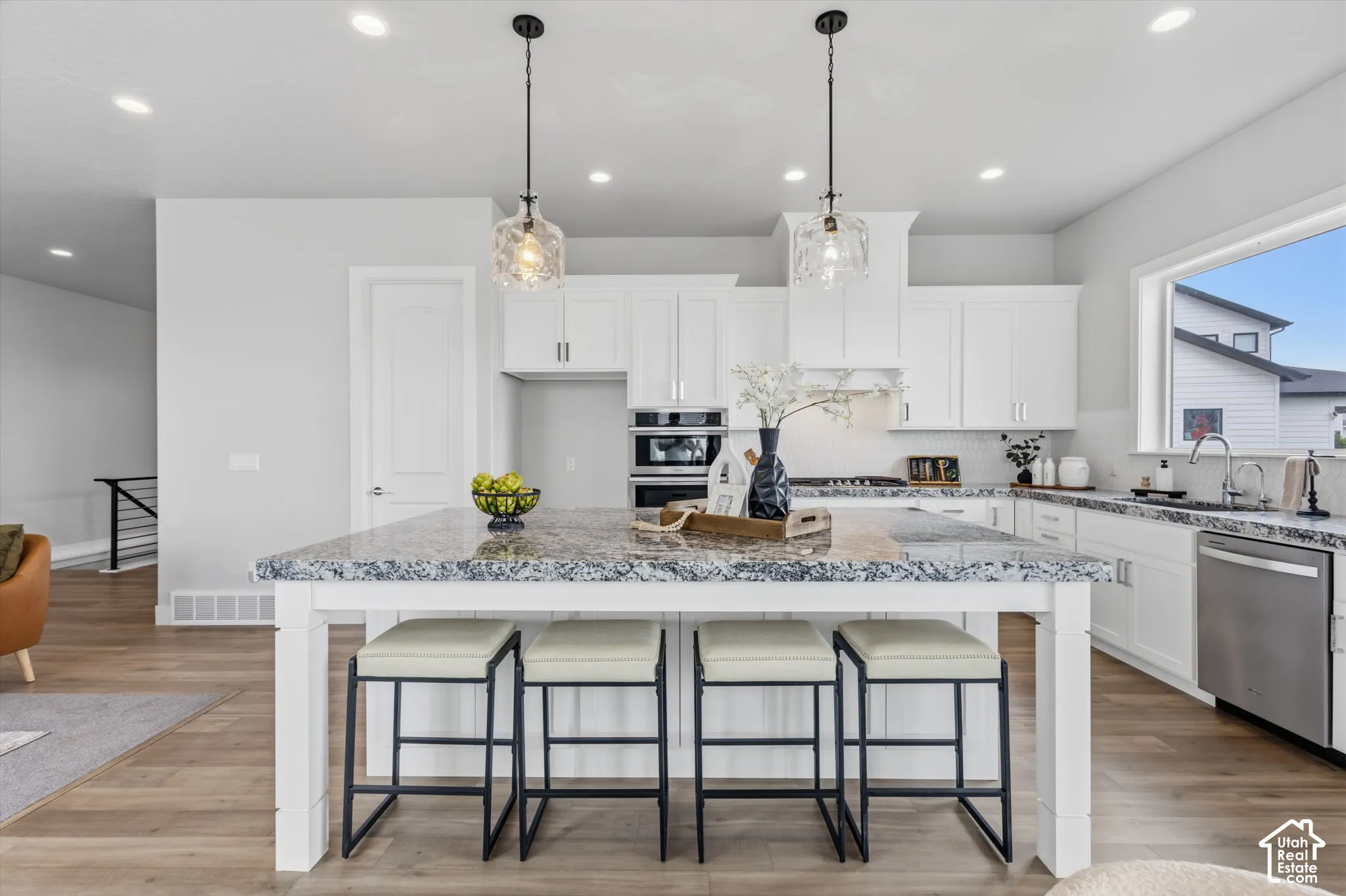 Kitchen island with a light-toned countertop and pendant lighting